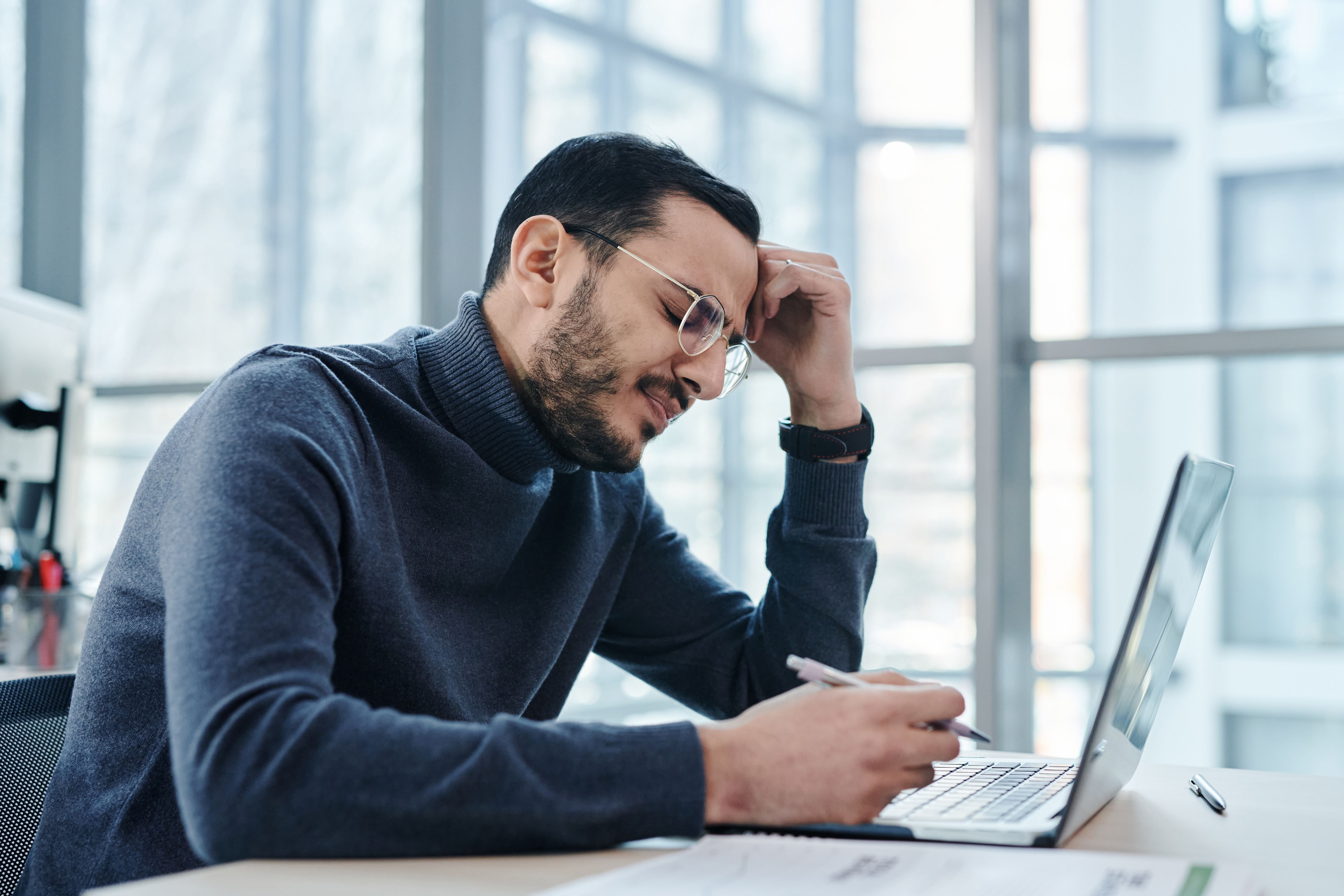 Freudiger Büromitarbeiter nutzt einen Laptop